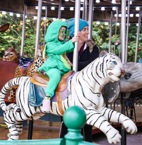 Guest in costume riding Boo at the Zoo Carousel