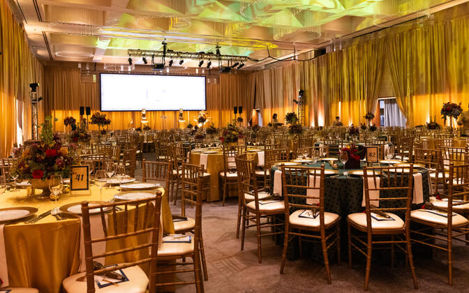 Ballroom with gold sequins and satin drape that paired with alternating emerald and gold linens